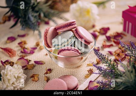 Different types of macaroons in glass bowl, still life Stock Photo