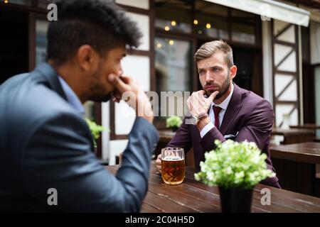 Two sceptical business men talking on a meeting outdoor Stock Photo