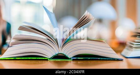 Open book lying on the table in the public library Stock Photo