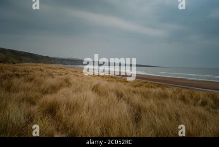 Panoramic view of St Cyrus beach with rocks, sea and house on the cliff on blue sky background. Scotland, United Kingdom. April 2019 Stock Photo