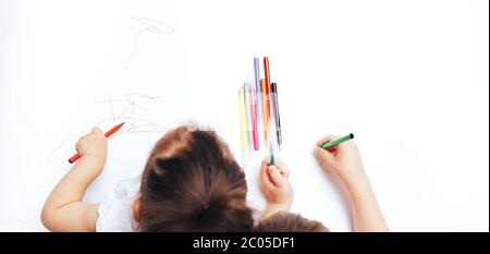 Talented children draw with colored felt-tip pens on white paper, lessons, tasks with children of the different ages Stock Photo