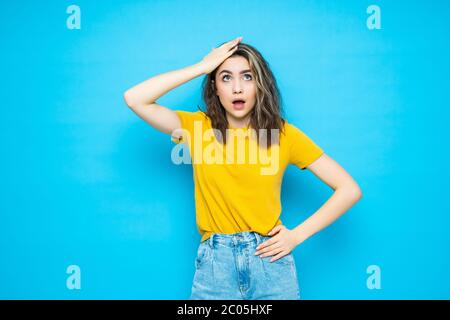 Young woman isolated on blue background forgetting something, slapping forehead with palm and closing eyes. Stock Photo