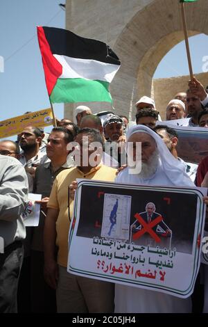 Rafah, Gaza. 11th June, 2020. Palestinians lift placards during a protest against Israel's plans to annex part of the occupied West Bank, at Rafah in the southern Gaza Stri, on Thursday, June 11, 2020. Israel has signaled it intends to annex West Bank settlements and the Jordan Valley, with initial steps slated to begin from July 1. Photo by Ismael Mohamad/UPI Credit: UPI/Alamy Live News Stock Photo