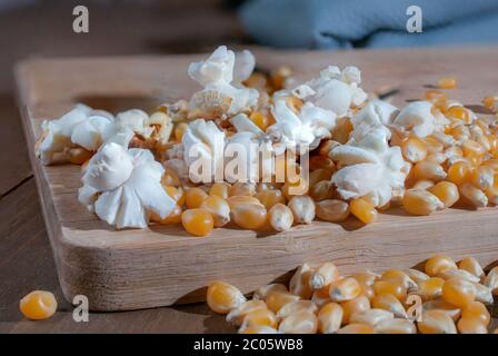 Dried corn and popcorn on a wooden cutting board, close up or macro photography. Stock Photo