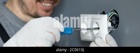 Handyman using screwdriver to install sockets Stock Photo