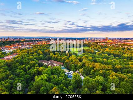 English garden with economy building, beer garden at the Chinese Tower and Monopteros, view over the city center in the morning light, Munich, aerial Stock Photo