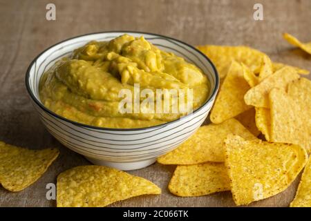 Fresh homemade guacamole and tortilla at a wooden table Stock Photo