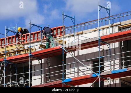 Construction worker on scaffolding, new construction of apartment buildings construction site, Essen, North Rhine-Westphalia, Germany Stock Photo