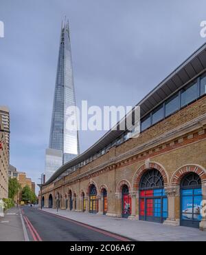 The renovated arches of London Bridge Network Rail station point towards the Shard, a 95 storey tower that is part of the Shard Quarter area. Stock Photo