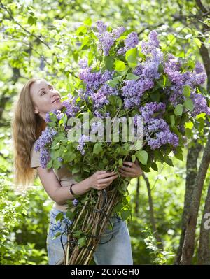 woman in park with a big bouquet of a lilac Stock Photo