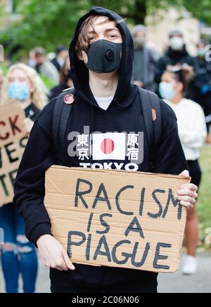Newport, Wales, UK. 11th June, 2020. A protester wearing a face mask holds a placard during the Black Lives Matter March in Newport. Hundreds of people joined the protest following the death of George Floyd, a 46 year old, African-American man, who died during an arrest by the Minneapolis police for allegedly using a counterfeit bill. His death has sparked huge protests across the world against racial discrimination. Credit: Tracey Paddison/Alamy Live News Stock Photo