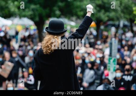 Newport, Wales, UK. 11th June, 2020. A speaker raises his arm in the air to the crowd below during a Black Lives Matter march in Newport today. Hundreds of people joined the protest following the death of George Floyd, a 46 year old, African-American man, who died during an arrest by the Minneapolis police for allegedly using a counterfeit bill. His death has sparked huge protests across the world against racial discrimination. Credit: Tracey Paddison/Alamy Live News Stock Photo