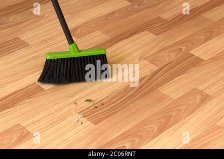 The green instrument for cleaning the premises is on the floor of the laminate Stock Photo