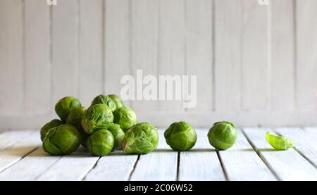 Vegetable concept. A pile of fresh Brussels sprouts isolated on wooden table. Blurry background. Copy space. Stock Photo