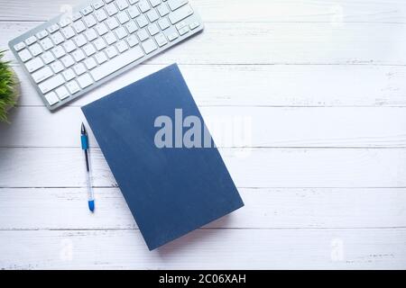 book with empty cover, pen and keyboard on table  Stock Photo