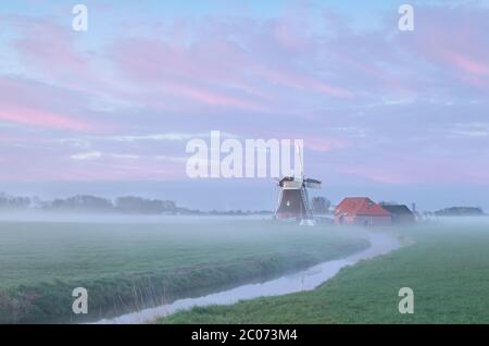 Dutch windmill in dense morning fog Stock Photo