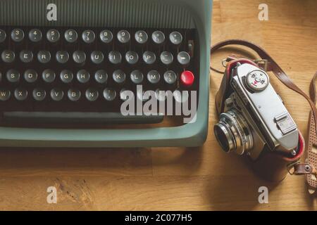 Old photo camera and blue vintage typewriter on a desk Stock Photo