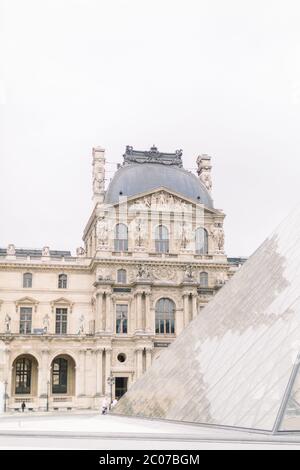 PARIS, FRANCE - September 17, 2019: Wonderful view of Louvre palace and glass pyramid and unrecognizable people tourists visiting Louvre Museum. It Stock Photo