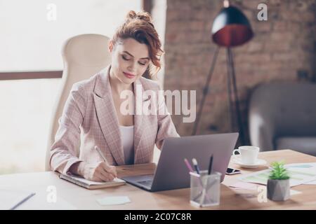 Portrait of her she nice attractive pretty elegant chic classy focused smart lady sitting in chair writing plan strategy development at modern Stock Photo
