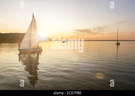 Sailing boats coming back into the harbor during beautiful sunset at the Baltic Sea Stock Photo