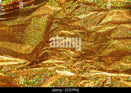 Sparkle glitter gold background. Gold foil leaf metallic wrapping paper shiny texture. Crumpled wrapping paper. Stock Photo