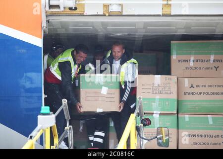 Calum Best (right) and Tamer Hassan help to unload boxes of Personal Protection Equipment (PPE) from a plane at Robin Hood Airport in Doncaster, South Yorkshire. ??30,000 worth of PPE has been donated to the Mask Our Heroes charity, which was set up by entrepreneur Matthew McGahan in the wake of the coronavirus outbreak to help supply frontline NHS and health workers with the protective equipment they need. Stock Photo
