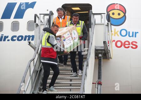 Calum Best (left) and Tamer Hassan help to unload boxes of Personal Protection Equipment (PPE) from a plane at Robin Hood Airport in Doncaster, South Yorkshire. ??30,000 worth of PPE has been donated to the Mask Our Heroes charity, which was set up by entrepreneur Matthew McGahan in the wake of the coronavirus outbreak to help supply frontline NHS and health workers with the protective equipment they need. Stock Photo