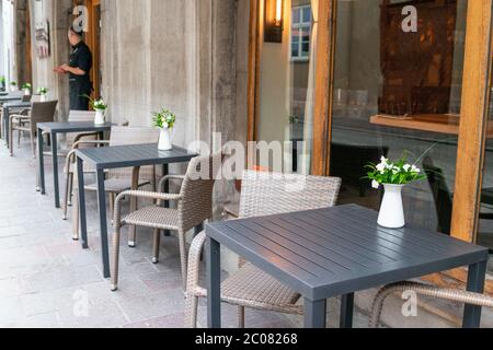 Black table and chair with white flowers in a vase outdoor. Outdoor cafe in the summer Stock Photo