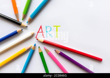 Colorful art pencil layed out on a white paper with the word art written on it. Copyspace. Stock Photo