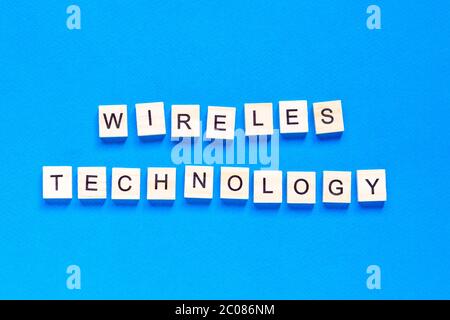 wireless technology lettering in wooden letters. The words wireless technology, spelt with wooden letter tiles over a white background. Stock Photo
