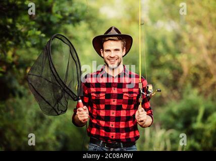 Big game fishing. fisher hold fish net. hobby. man checkered shirt on  ranch. fisherman with fishing rod. man in cowboy hat. western portrait.  Vintage style man. Wild West retro cowboy. fly fishing