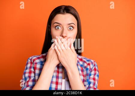 Close-up portrait of her she nice attractive lovely scared straight-haired girl wearing checked shirt closing mouth don't speak isolated over bright Stock Photo