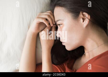 A woman suffering from deep depression, thinking about her problems, lying on Stock Photo
