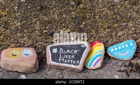 Port Seton, East Lothian, Scotland, UK. 11th June 2020. Covid-19 pandemic symbols created by locals: a line hundreds of feet long on the seafront promenade of colourful and creative hand-painted stones with inspiring messages. It seems to be a phenomenon spreading around the towns & villages of East Lothian. Black Live Matter and rainbow stones Stock Photo