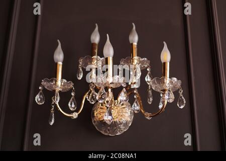 Wall chandelier attached to wood brown wall with light. Retro style in the interior Stock Photo