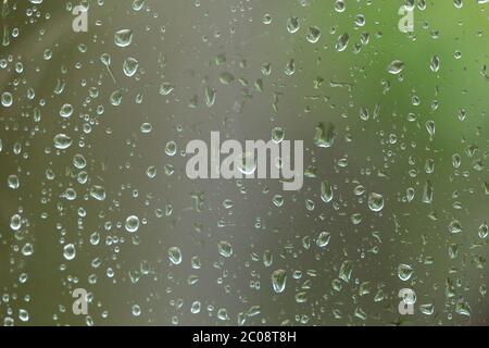 Raindrops on a window pane from the inside of a house. Stock Photo