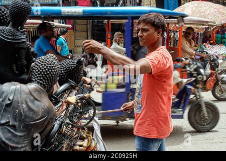 Shankar Kumar sells decorative Buddha statues that his family makes at a popular tourist market in New Delhi, India. Statues cost from 250 to 500 Indian rupees ($3.50 to $7) depending on the size, and he sells about 10 every day. (Aliya Bashir, GPJ India) Stock Photo