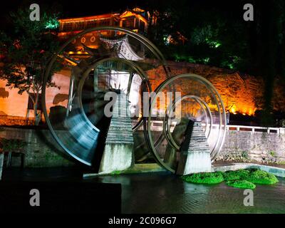 Vintage watermill wheel in Lijiang Old Town by night, Yunnan, China Stock Photo