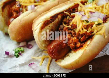 Homemade Chili dogs topped with cheddar cheese, selective focus Stock Photo