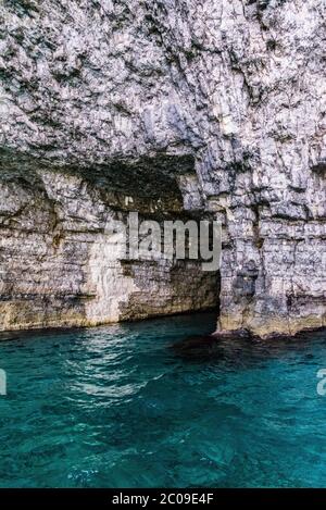 Clear sea water in the bottom of the rock on the entrance to natural tunnel Stock Photo