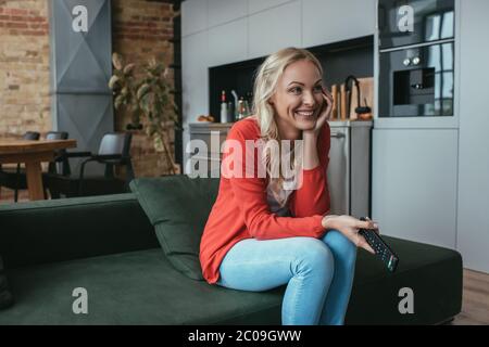 cheerful woman laughing while watching tv at home Stock Photo