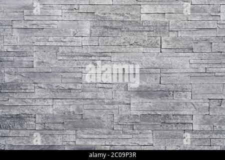 Stacked stone tiles are often used in interior design decors as accent wall. Use this gray texture in graphic design to create a wallpaper, background Stock Photo