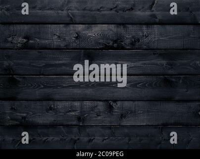 Dark black wood texture background viewed from above. The wooden planks are stacked horizontally and have a worn look. This surface would be great as Stock Photo