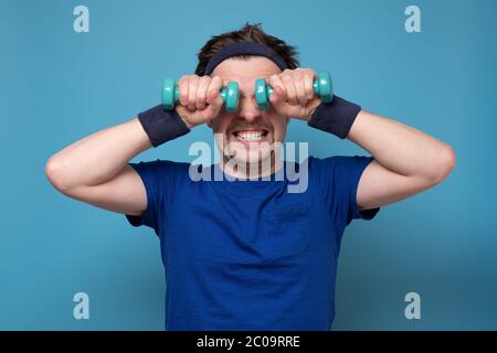 Athletic funny young man doing exercise dumbbell Stock Photo