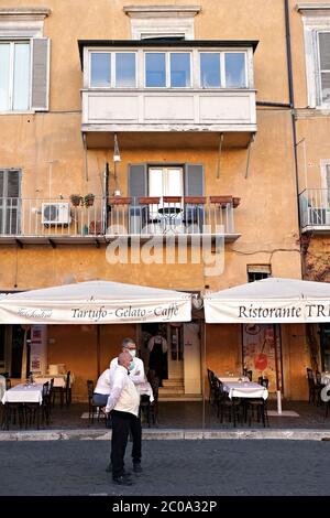Waiters of a famous restaurant in Piazza Navona, waiting for any customers. Empty tables because of the Covid 19 Coronavirus. Rome at the time of Covid 19. Italy, Europe, European Union, EU. Stock Photo