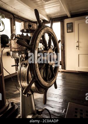 Steering wheel in the old war ship Stock Photo