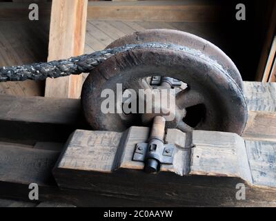 Detailed view of a rusty drag metal wheel as a part of pulley Stock Photo