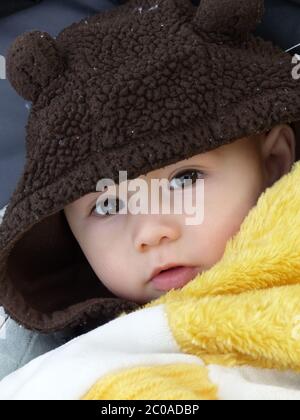 Baby Wrapped In A Blanket Looking Directly At Camera Stock Photo