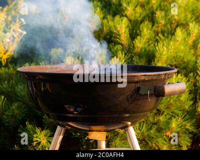 Lighting up a small black round grill Stock Photo