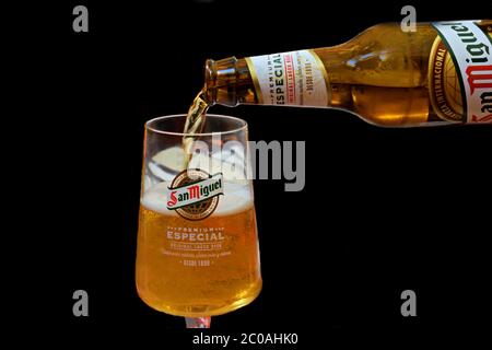 glass of beer and bottle of famous Spanish San Miguel beer on a black background. Stock Photo